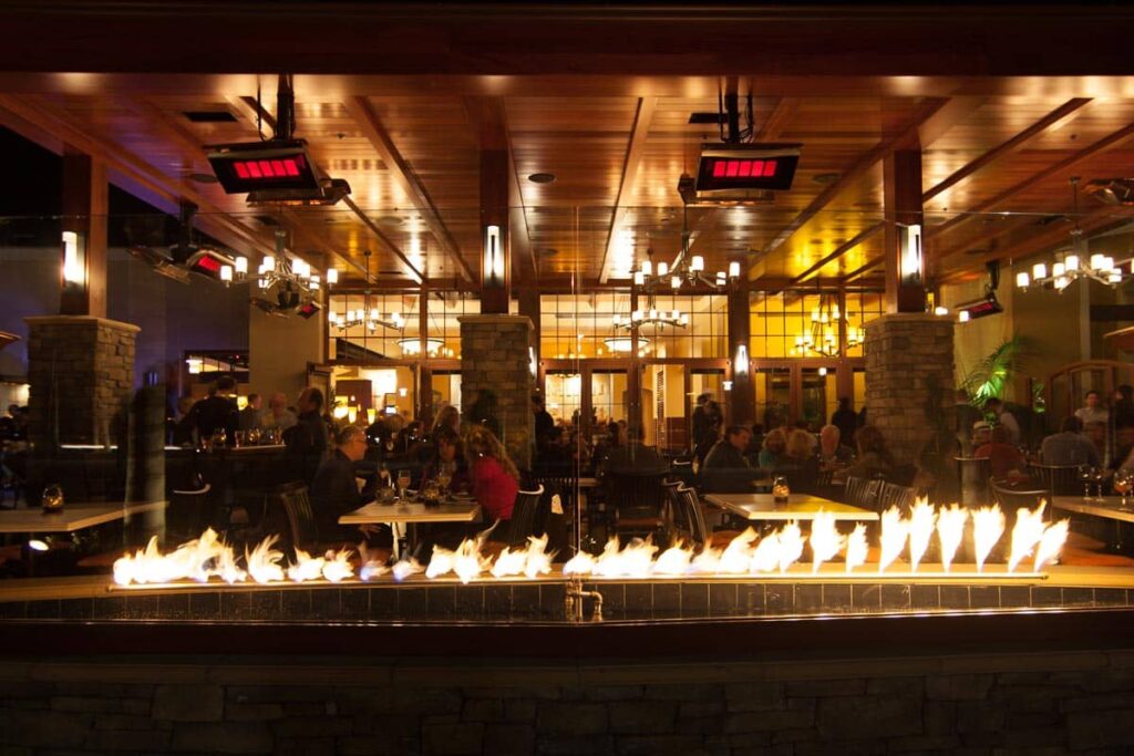 restaurant animé et faiblement éclairé avec comptoir de feu et chauffages au gaz